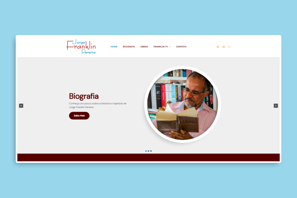 A imagem mostra a captura de tela de um site com fundo azul claro. O conteúdo principal está centralizado em uma moldura branca com cantos arredondados. Na parte superior está o cabeçalho com o logotipo do site que diz “Jorge Franklin Pereira”, com um estilo de fonte artística nas cores vermelha e azul clara. Ao lado do logotipo há um menu de navegação com as seguintes opções: Home Biografia Obras Franklin TV (com um ícone indicando que há um submenu) Contato À direita do menu, há ícones pequenos das redes sociais: Facebook, YouTube e Instagram. Abaixo do cabeçalho está um carrossel de conteúdo (tipo apresentação de slides). O slide atual apresenta, à esquerda, o título “Biografia” em letras grandes e escuras, seguido da frase: “Conheça um pouco sobre a história e trajetória de Jorge Franklin Pereira.” Abaixo do texto, há um botão escuro com texto branco que diz: “Saiba Mais”. À direita desse texto, há uma foto circular de um homem de meia-idade, Jorge Franklin Pereira, com óculos e barba grisalha, usando uma camisa rosa. Ele está lendo o livro "Ulysses" de James Joyce, e ao fundo há uma estante com diversos livros. Na parte inferior do carrossel há três pequenos círculos que indicam a posição no carrossel, com o segundo círculo preenchido, sinalizando que esse é o slide atual. Abaixo disso, há uma faixa horizontal larga de cor vinho escura.